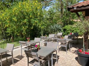 a row of tables and chairs on a patio at La Chêneraie Chambres d'hôtes-B&B in Payrac