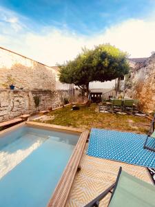 a swimming pool with two chairs and a table at Joli Studio Dépendance Lectoure Intra-muros in Lectoure