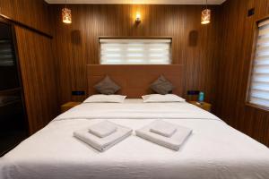 a bedroom with a large bed with two towels on it at The VARKALA HAVEN 105 in Varkala
