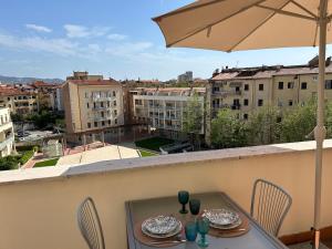 a table and chairs on a balcony with an umbrella at A & M Appartamento con garage in Livorno