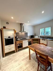 a large kitchen with a wooden table and a dining room at La Maison du Square in La Teste-de-Buch