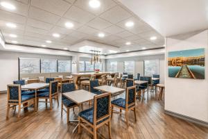a dining room with tables and chairs and a painting on the wall at Hampton Inn Milledgeville in Milledgeville