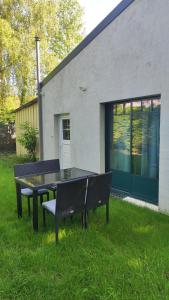 ein Tisch und Stühle im Gras vor einem Gebäude in der Unterkunft Studio Grimm - Tiny House in Le Cellier + 7 Fotos