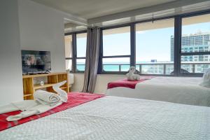 a hotel room with two beds and a large window at Oceanview Apartment on the beach 123 in Miami Beach +32 photos