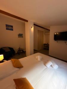 a bedroom with a large white bed with a flat screen tv at Casa Stella in Olmeto