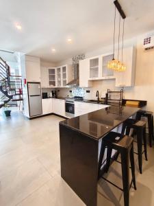 a kitchen with white cabinets and a large island with stools at Crystal Apartments in Malindi