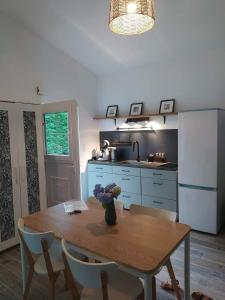 eine Küche mit einem Tisch, auf dem eine Blumenvase steht in der Unterkunft Studio Grimm - Tiny House in Le Cellier