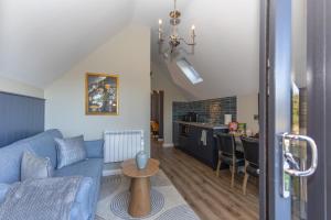 a living room with a blue couch and a kitchen at Narrow Water Lodges in Cornamucklagh