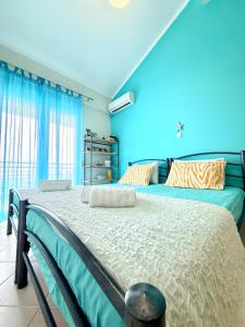 a bedroom with a large bed with blue walls at SEASIDE MAISONETTE in Aroyí