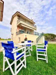 two chairs and a table in front of a house at SEASIDE MAISONETTE in Aroyí