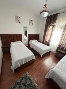 a bedroom with two beds and a chandelier at Kruja Grande Hotel in Krujë