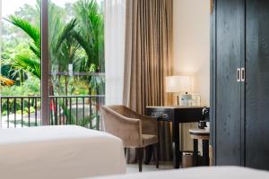 a hotel room with a bed and a desk and a window at The Royal Corin Thermal Water Spa & Resort - Adults Only in Fortuna +48 photos