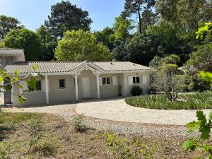 a white house with a driveway at La Maison du Square in La Teste-de-Buch