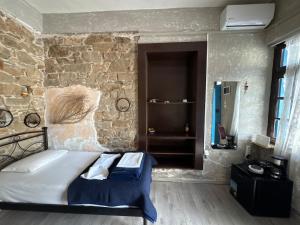 a bedroom with a bed with a stone wall at Anthemis home II in Agios Kirykos +10 photos