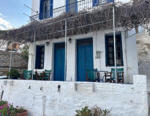 a white house with blue doors and a table at Anthemis home II in Agios Kirykos