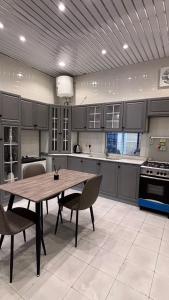 a large kitchen with a wooden table and chairs at شاليه الجاكرندا 8 in Taif