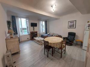 a living room with a table and a room with a couch at Studio petite perle in Bargemon