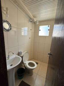 a bathroom with a toilet and a sink at Pousada Vento Leste in Cabo Frio