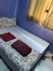 a bed with two towels on it in a room at Casa Takahashi in Ariquemes