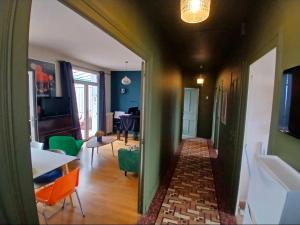 a hallway with a living room with green walls at Cyrus House - maison complète 90m2 in Le Mans