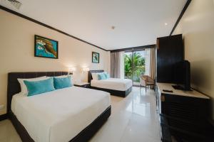 a hotel room with two beds and a television at The Royal Corin Thermal Water Spa & Resort - Adults Only in Fortuna
