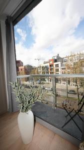 a white vase sitting on a floor next to a window at Anvers Apartment in Antwerp