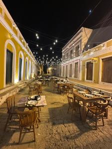 a group of tables and chairs in a street at night at Pousada Refúgio Do Cangaço in Piranhas
