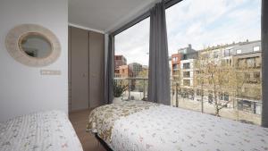 a bedroom with a bed and a large window at Anvers Apartment in Antwerp