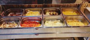 a buffet of different types of food in trays at Pousada Refúgio Do Cangaço in Piranhas