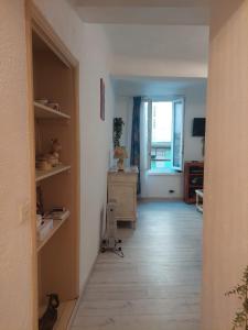an empty room with a hallway with a table and a window at Studio petite perle in Bargemon +3 photos