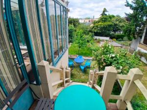 a balcony with a blue table and chairs at Cyrus House - maison complète 90m2 in Le Mans