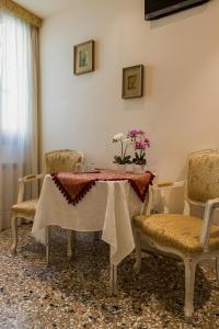 a dining room with a table with chairs and flowers on it at Inn Venice in Venice