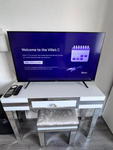 a flat screen tv sitting on top of a table at The Villas in Rock Ferry