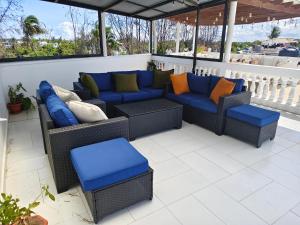 a patio with wicker chairs and pillows on a balcony at Crystal Apartments in Malindi