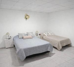 a bedroom with two beds and a bedskirts at Hospedaje Don Felix in General Acha
