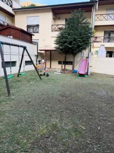 an empty yard with a playground in front of a building at Casa da Lagoa II in Terras de Bouro