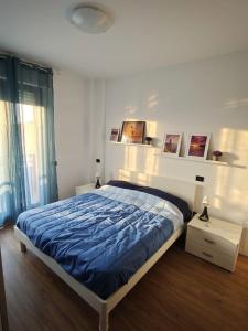 a bedroom with a large bed with a blue comforter at Casa Cesare in Cagliari