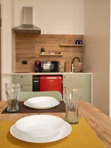 a wooden table with two plates and glasses on it at Casa Cesare in Cagliari