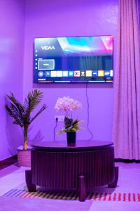 a purple room with a vase of flowers on a table at JIV Luxury Homes in Mwanza +10 photos