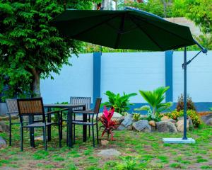 a table and chairs under a green umbrella at JIV Luxury Homes in Mwanza
