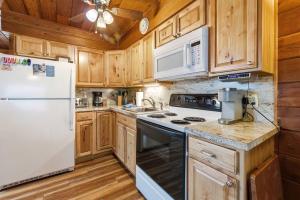 a kitchen with white appliances and wooden cabinets at Chalet #44 in Stevensville