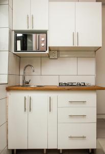 a white kitchen with a sink and a microwave at Clearview Estuary Apartments in East London