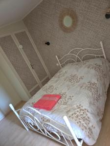 a white bed with a red towel on it in a room at Maison individuelle climatisé, 3 minutes du pal in Thiel-sur-Acolin