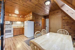 a kitchen with a table and a white refrigerator at Chalet #39 in Stevensville +35 photos