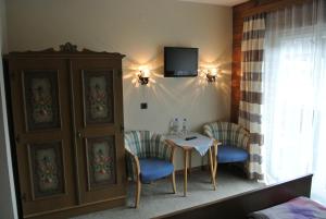 a room with a table and chairs and a tv at Haus Grützner in Dorfgastein