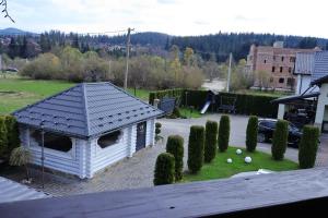 a small white house with a roof on a yard at VIP House cottages in Mykulychyn