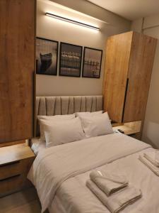 a bedroom with a large bed with two towels on it at Lounetta Apartments 1 in Missolonghi