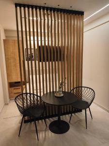 a table and chairs in a room with a wooden wall at Lounetta Apartments 1 in Missolonghi