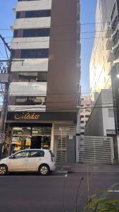 a white car parked in front of a building at Apartamento perto do HCAA - com Garagem in Santa Maria