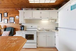 a kitchen with white appliances and a wooden ceiling at Chalet #29 in Stevensville
